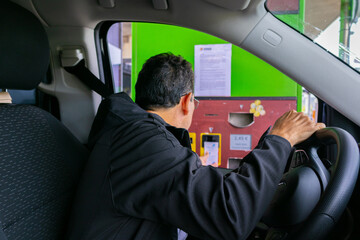 Adult male paying a toll on the highway - obrazy, fototapety, plakaty