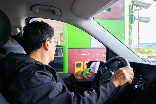 Adult male paying a toll with a credit card