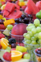 Mixed fruit salad with strawberry, watermelon, fig, cherry and grape. Selective focus of fruits. Veritcal fruit background wallpaper.