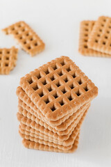 A stack of swet square biscuits on a white background.
