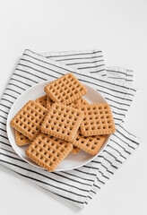 Sweet crunchy square cookies on a plate. Copy space.