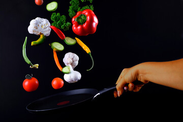 vegetables levitation under the wok in hand of cooker