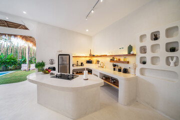 White kitchen with stone table with gas stove. Overlooking the pool in the garden. Holiday concept