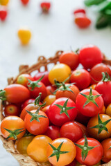 Fresh cherry tomatoes close up in a wicker basket. Delicious red and yellow mini tomatoes.