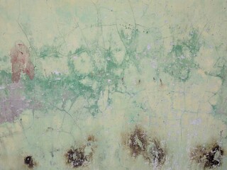 Weathered concrete wall of green soft color covered with scratched digits and equations
