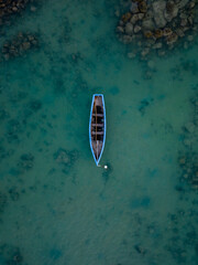 Aerial top view of a sailboat in a turquoise sea