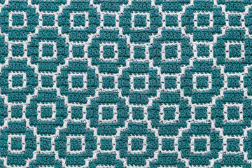 Abstact knitted background. Crochet mosaic pattern. Seamless turquoise white crochet texture.