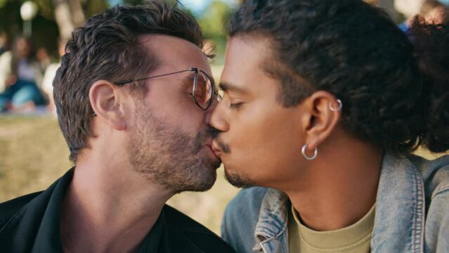 Portrait gay lovers kissing sitting nature at romantic weekend. Transgender men