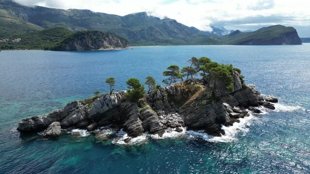 Church on the rock on Katic islet in Petrovac na Moru Aerial View. Beaches and coastline of the Adriatic Sea at summer time. Natural landscapes of Montenegro. Balkans. Europe.