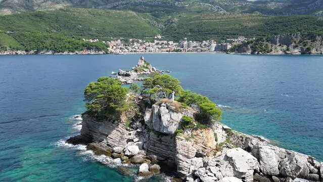 Church on the rock on Katic islet in Petrovac na Moru Aerial View. Beaches and coastline of the Adriatic Sea at summer time. Natural landscapes of Montenegro. Balkans. Europe.