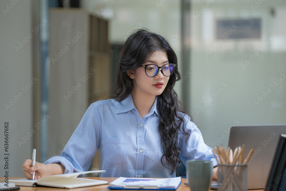 Poster a businesswoman or accountant using writing a notebook while working on analytic business reports on