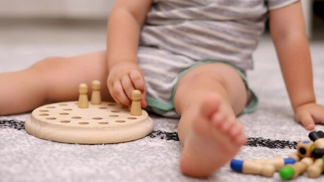 baby boy playing at home wooden memory matchstick chess game, funny block board.child kid sitting on floor putting on or remove pieces.spinning board, throwing cube,colorful pieces 4k