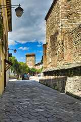 Bevagna Town, Umbria, Italy.  A characteristic paved street with on the right the Roman temple...