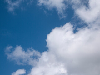 Obraz premium White fluffy clouds in the deep blue sky background