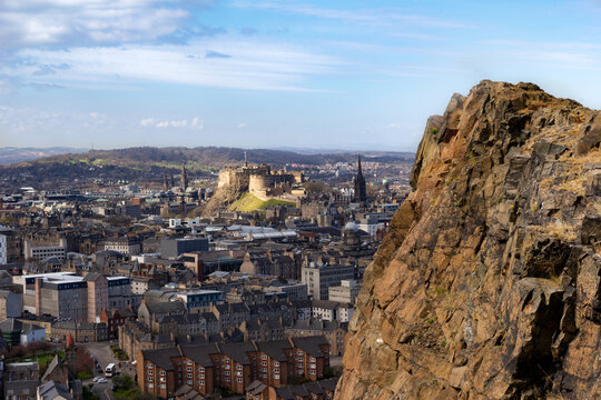 Edinburgh castle sun-bathed on its rocky fortress and Salisbury Crags