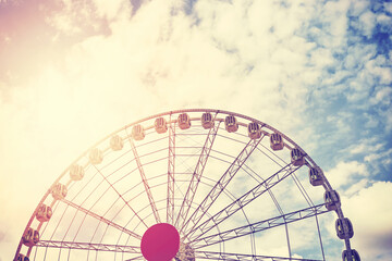 Color toned picture of a Ferris wheel against the sky, color toning applied.