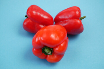 red sweet peppers on blue background, bellpeppers, paprika,
