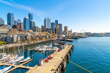 Panoramic view of the Seattle Waterfront along the Puget Sound with downtown district skyscrapers, the Pike Place Market district, and Great Wheel in view from the harbor in Seattle Washington, USA.	 - obrazy, fototapety, plakaty