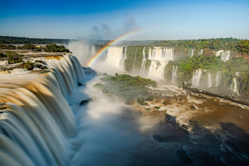 Perfect rainbow over Iguazu Waterfalls, one of the new seven natural wonders of the world in all its beauty viewed from the Brazilian side - traveling South America - long exposure