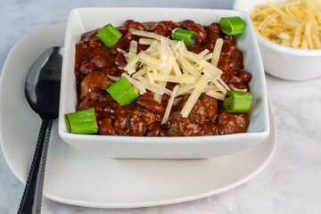 bowl of chili top with scallions and cheese
