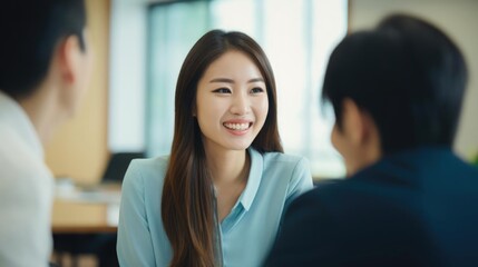 Obraz premium Smiling asian female social worker talking to her colleagues