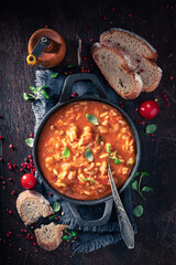 Delicious minestrone soup served with bread and herbs.