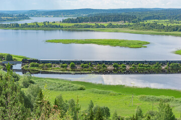 Retro steam train moves along the lake.