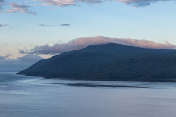 A Laurentian mountains cape covered in forest and the St. Lawrence River seen during a beautiful summer sunrise, Baie-Saint-Paul, Charlevoix, Quebec, Canada