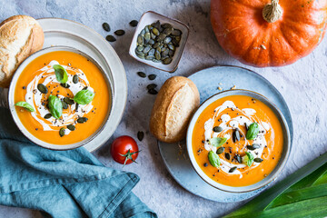 Pumpkin and Tomato cream soup topped with sour cream, pumpkin seeds and basil