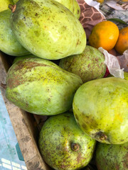 Traders at the market are selling various fresh fruits and vegetables