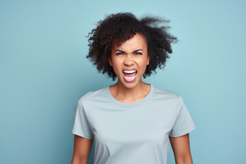 Fototapeta na wymiar Anger African Woman In Gray Tshirt On Pastel Background