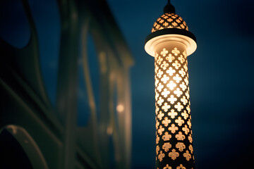 a mosques minaret illuminated at night