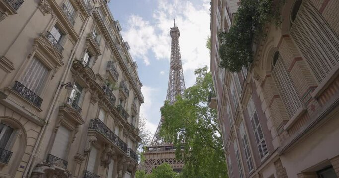 View of the Eiffel Tower from one of the famous streets of Paris. Parisian architecture of houses in the center of the capital. Houses of Paris in the background landmark iron tower