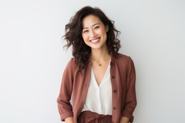 Fototapeta premium Lifestyle portrait of a Chinese woman in her 30s in a white background wearing a chic cardigan
