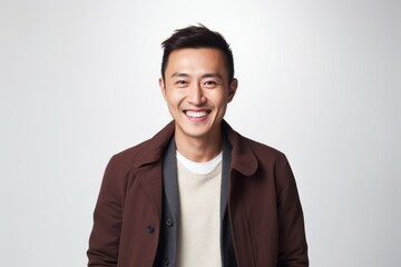 Fototapeta premium Medium shot portrait of a Chinese man in his 30s in a white background wearing a chic cardigan