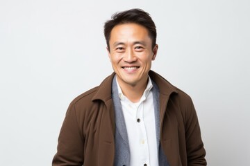 Lifestyle portrait of a Chinese man in his 40s in a white background wearing a chic cardigan
