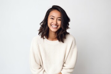 Fototapeta premium Medium shot portrait of a Indonesian woman in her 30s in a white background wearing a cozy sweater