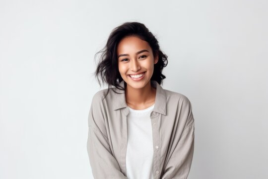 Medium shot portrait of a Indonesian woman in her 20s in a white background wearing a chic cardigan