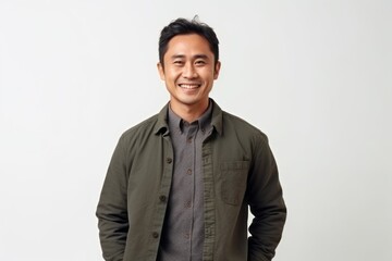 Fototapeta premium Portrait of a happy young asian man smiling against white background