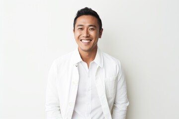 Portrait of happy young asian man smiling at camera against white background
