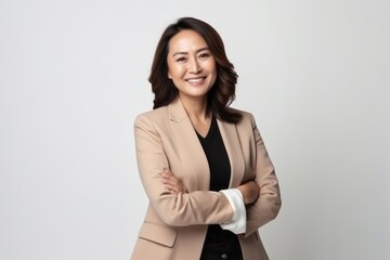 Medium shot portrait of a Indonesian woman in her 40s in a white background wearing a classic blazer