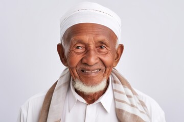 Lifestyle portrait of a 100-year-old elderly Indonesian man in a white background wearing a foulard