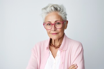 Portrait of smiling senior woman in eyeglasses against white background