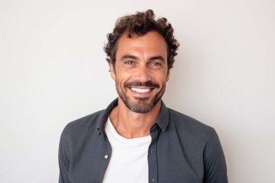 Medium shot portrait of a Brazilian man in his 30s in a white background wearing a chic cardigan