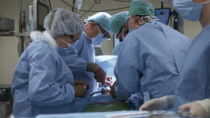 Team of doctors perform surgery in operating room using sterile instruments. Process of treating patient with invasive method. Healthcare in modern clinic - Powered by Adobe