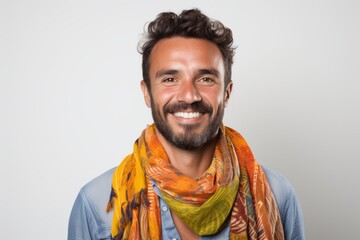 Lifestyle portrait of a Brazilian man in his 30s in a white background wearing a foulard