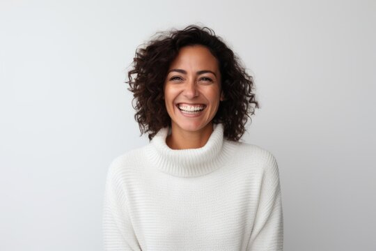 Medium shot portrait of a Brazilian woman in her 40s in a white background wearing a cozy sweater