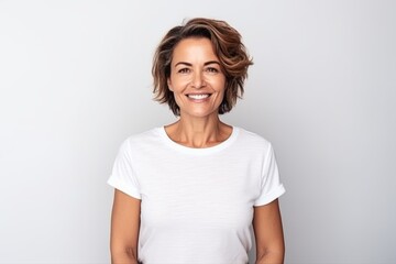 Fototapeta premium Medium shot portrait of a Brazilian woman in her 40s in a white background wearing a casual t-shirt