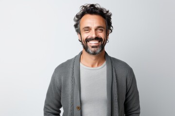Group portrait of a Brazilian man in his 40s in a white background wearing a chic cardigan