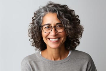 Lifestyle portrait of a Brazilian woman in her 50s in a white background wearing a cozy sweater
